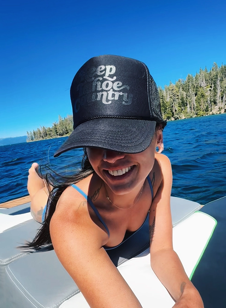 Local woman wearing Keep Tahoe Country hat on Lake Tahoe on a Summer day
